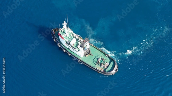Fototapeta Aerial drone top down photo of tug boat cruising in industrial carrier logistics terminal
