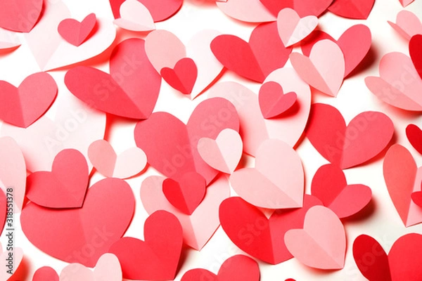 Fototapeta Bunch of cut out of pink and red paper hearts on white background closeup.