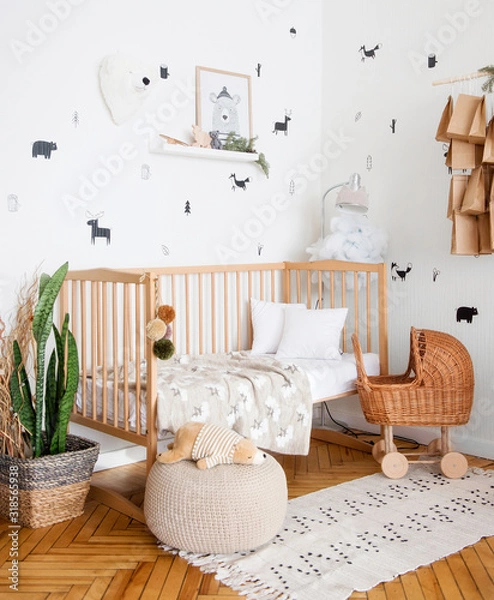 Obraz The cot is spread out. We see a crumpled pillow, plaid and blanket. The toy is also in bed. There is a toy baby stroller nearby.