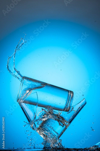 Fototapeta two tall glasses of liquid are broken into pieces and the contents are poured