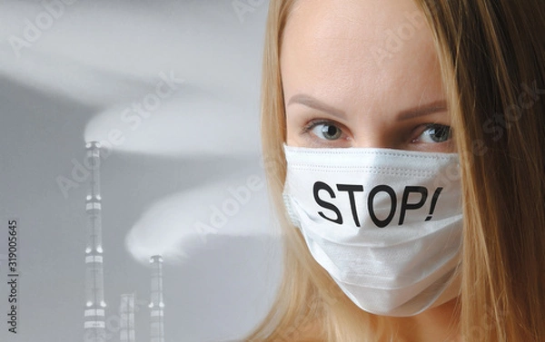 Obraz woman in a medical respiratory mask with the inscription stop close-up on a gray background. air pollution and global warming concept