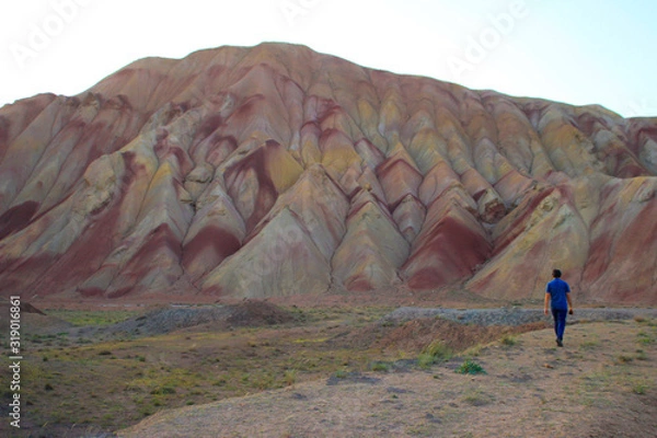 Obraz Tabriz, Iran - May 28, 2017: Stunning unusual colored mountains in Iran near Tabriz. Turis man on a background of mountains. Natural attractions of Iran.