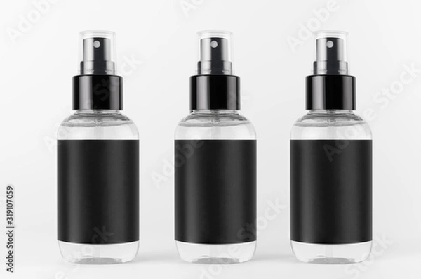 Fototapeta Three transparent spray bottles for cosmetics product with black blank label on white background, mock up for branding, advertising,  design.
