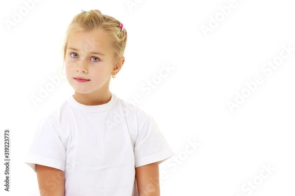 Obraz A little girl is sitting on the floor in a clean white T-shirt.