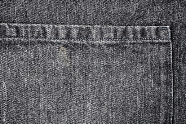 Obraz Ciemny materiał dżinsowy, tekstura. Zbliżenie fartuch z tkaniny denim z częścią kieszeni. Ziarnisty wzór teksturowanej tkaniny bawełnianej. Płaska powierzchnia denimu. Szare dżinsy, tło. Część kurtyny grunge.