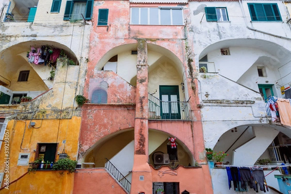 Fototapeta PROCIDA, ITALY - JANUARY 4, 2020 - The “Casale Vascello” is  a traditional colored courtyard surrounded by tall terraced houses in "Terra Murata", Procida.