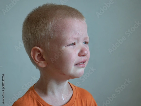 Fototapeta Blonde boy cries with tears. Upset child. Violence in family over children. Concept of bullying, depressive stress or frustration. Kid close up view. Pure authentic emotion. Copy space for text