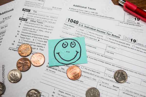 Fototapeta IRS 1040 tax return form with smiley face drawn on a sticker. Wage and tax statement concept