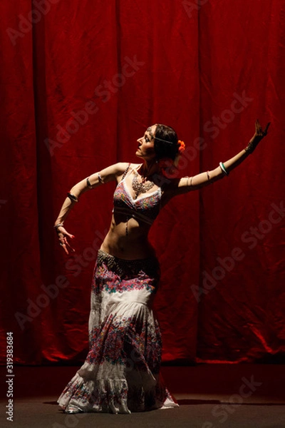 Fototapeta Dancer dancing belly dance on a concert stage.