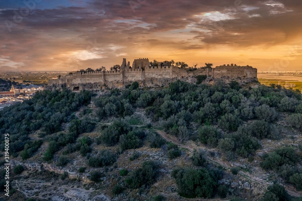 Fototapeta Aerial view of Corbera medieval Gothic castle in ruins on a hilltop near the coast with walls and a standalone tower in Spain 