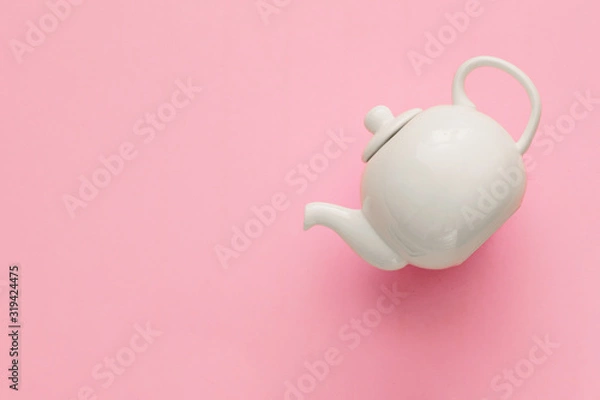 Fototapeta White porcelain teapot on a pink background, minimal art, close-up, flat lay