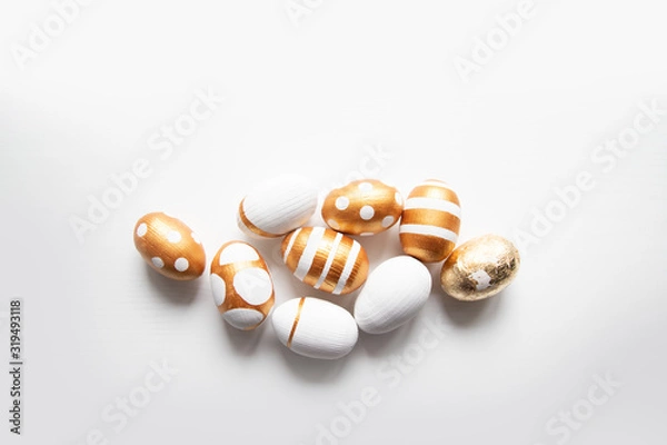 Fototapeta Easter golden eggs pattern on a white background with place for text.