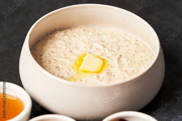 Fototapeta Healthy breakfast - milk rice porridge in a white plate on grey table background