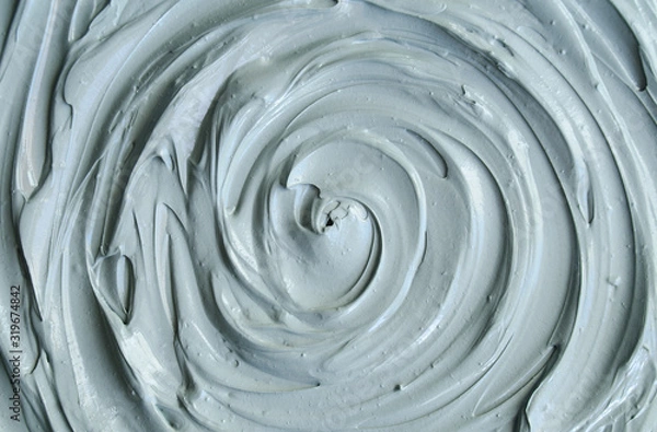Obraz Gray bentonite facial clay (mask, face cream, body wrap) texture close up, selective focus. Abstract background with circle brush strokes.