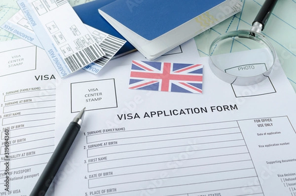Obraz Visa application form, passports, tickets,English flag, magnifying glass on the world map.Concept of cheking documents to get a visa