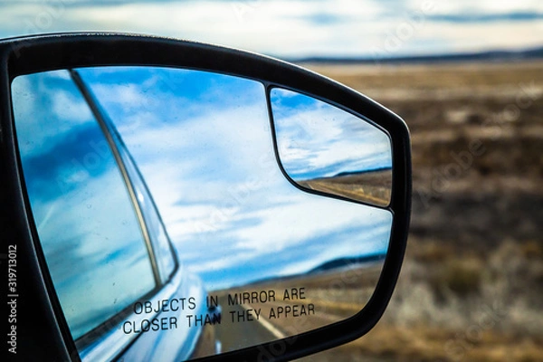 Fototapeta "Objects in the mirror are closer than they appear"safety warning written on the passenger side mirror of a car driving on the route 66 in southwest USA