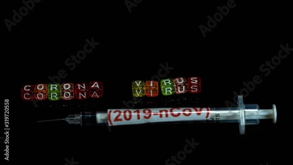 Fototapeta Colorful text "Corona virus" and   syringe have red text "(2019-nCoV)  put on  Black background. corona virus Concept.