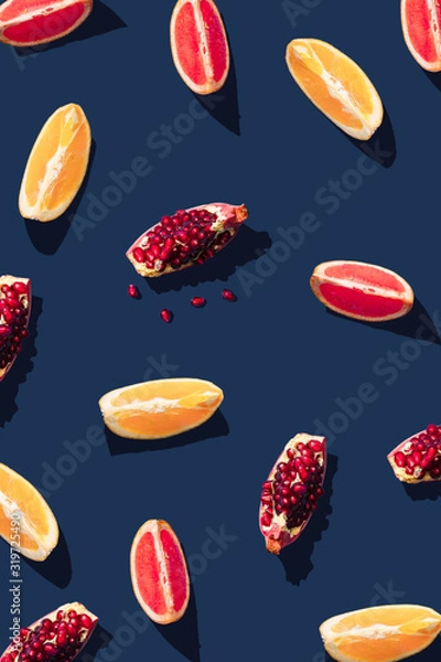 Fototapeta Flat lay pattern with summer citrus fruit on blue background. Minimal concept with sharp shadows. Trendy social mockup or wallpaper.