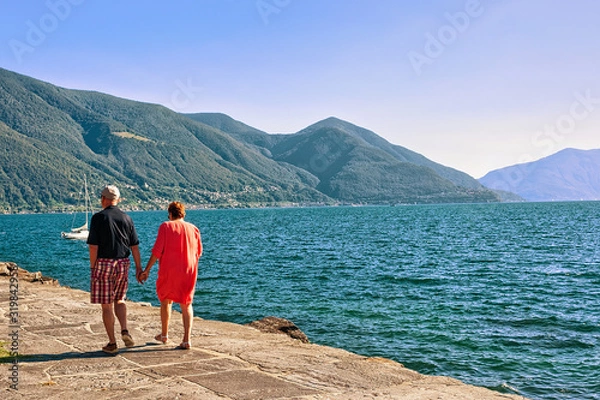 Fototapeta Couple passing by at the promenade at the luxurious resort in Ascona on Lake Maggiore in Ticino canton in Switzerland.