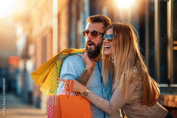 Fototapeta Happy couple enjoying after shopping in the city