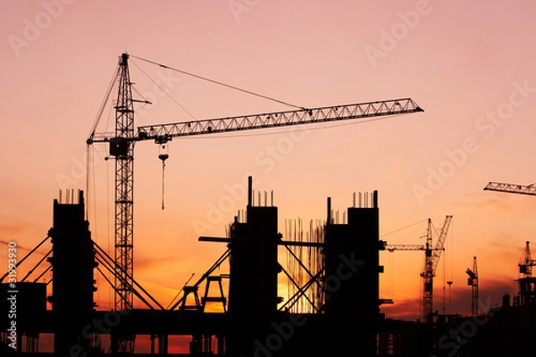 Obraz construction site with construction cranes at sunset