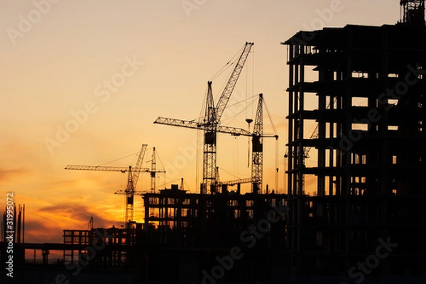 Obraz construction site with construction cranes at sunset
