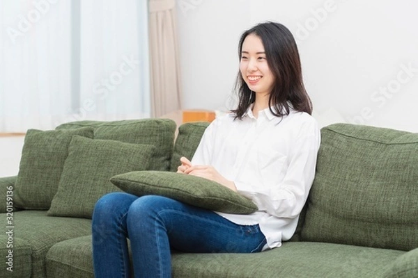 Fototapeta リビングのソファーに座る女性