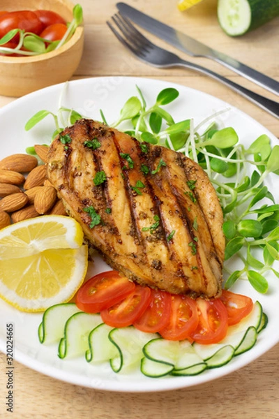 Fototapeta Top view of Fresh salad with chicken breast in white dish on wooden table, Almond,Sunflower seedling,Cucumber,Tomato,Lemon.