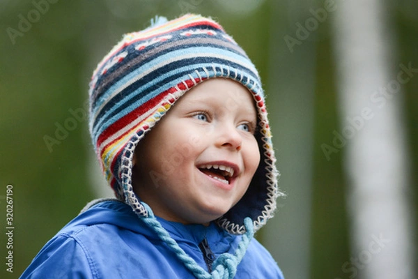Fototapeta Happy cheerful smiling boy with blue eyes, wearing hat
