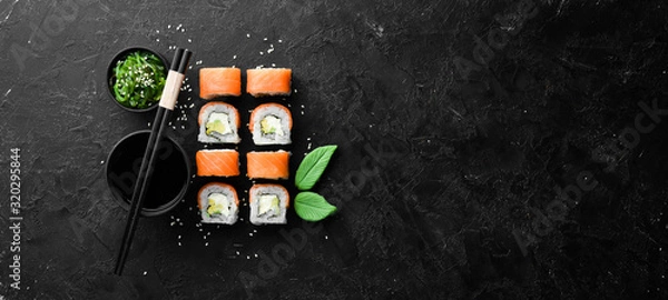 Fototapeta Philadelphia sushi roll with salmon and avocado. Japanese Traditional Cuisine. Top view. Rustic style.