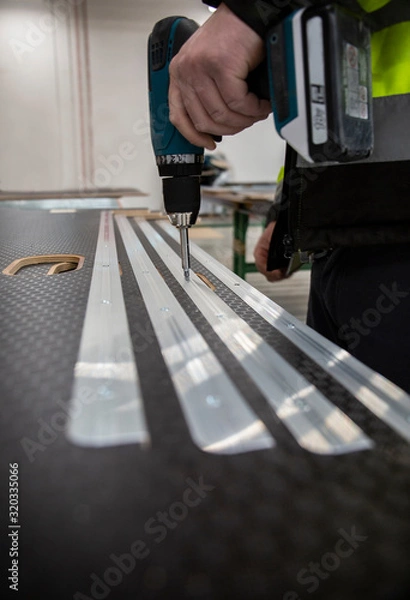 Obraz Przykręcanie szyn do podłogi samochodowej.