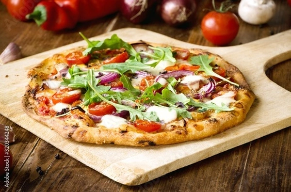 Obraz Świeżo upieczona pizza z rukolą, pomidorem, czerwoną cebulą i mozzarellą