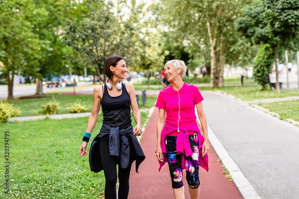 Obraz Happy mother and daughter enjoying in walk outdoors in park.