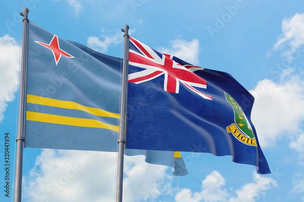 Fototapeta British Virgin Islands and Aruba flags waving in the wind against white cloudy blue sky together. Diplomacy concept, international relations.
