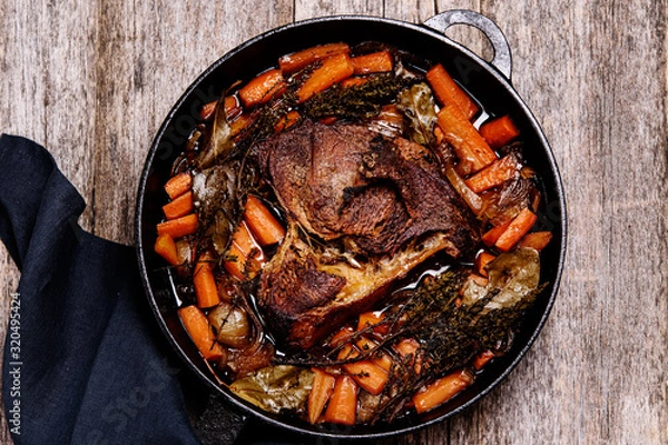 Fototapeta Braised beef brisket big piece with carrots and onion sauce serve in a hot pan