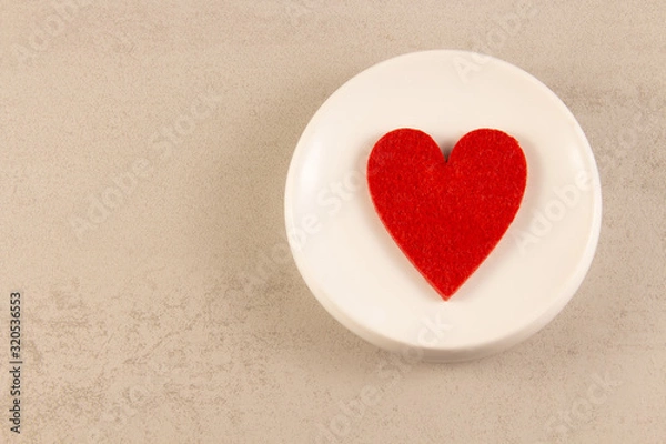 Fototapeta red heart symbol on a white plate. view from above. Romance and valentines day concept .copyspace for text