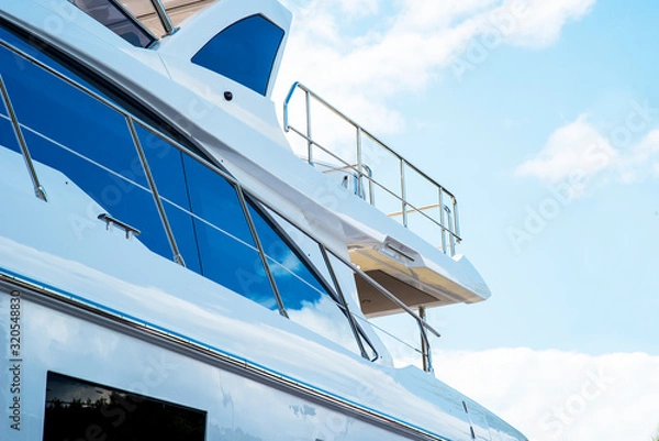 Fototapeta Nautical background of luxury yachts, with black tinted windows and chrome metal railings on white fiber glass bows