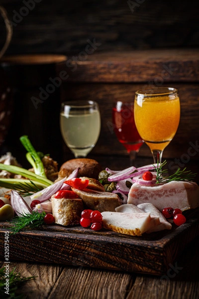 Fototapeta European cuisine in Ukrainian style. Meat set of homemade sausage, lard and bread. Serving dishes in a restaurant on wooden board with alcoholic drinks. background image copy space