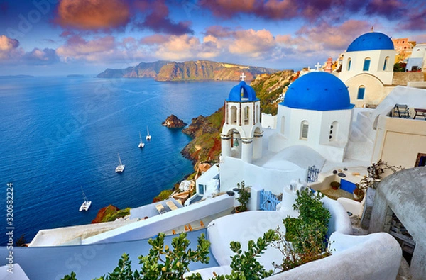 Obraz Miasto Fira na wyspie Santorini, Grecja. Niesamowicie romantyczny wschód słońca na Santorini. Wioska Oia w świetle poranka. Niesamowity widok zachodu słońca z białymi domami. Wyspa kochanków