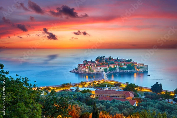 Obraz Amaizing sunset view on Sveti Stefan Island City. Small islet and resort in Montenegro. Balkans, Adriatic sea, Europe. Dramatic red sky under a Saint Stefan peninsula.