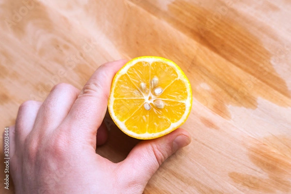 Fototapeta cut lemon in hand