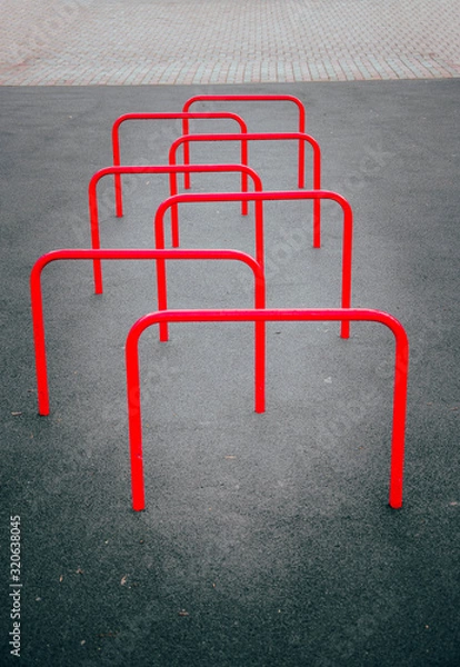 Fototapeta Red sports equipment stick out of the ground in a checkerboard pattern for snake running  around