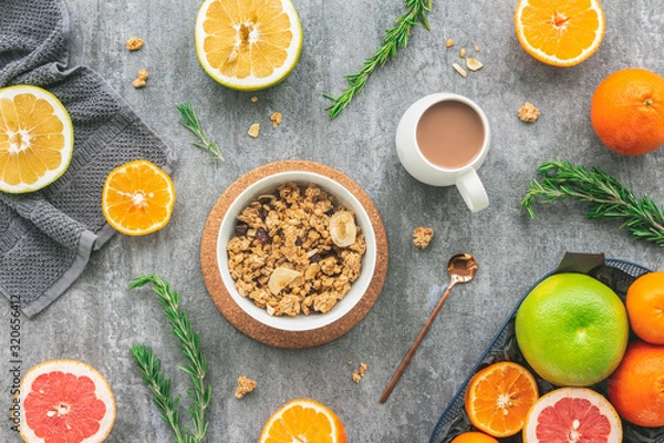 Obraz Tangerines, grapefruit, orange fruit, muesli, granola on dark gray background, flat lay, top view