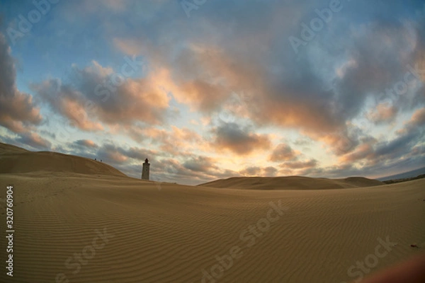 Obraz Lighthouse on beach in sunset