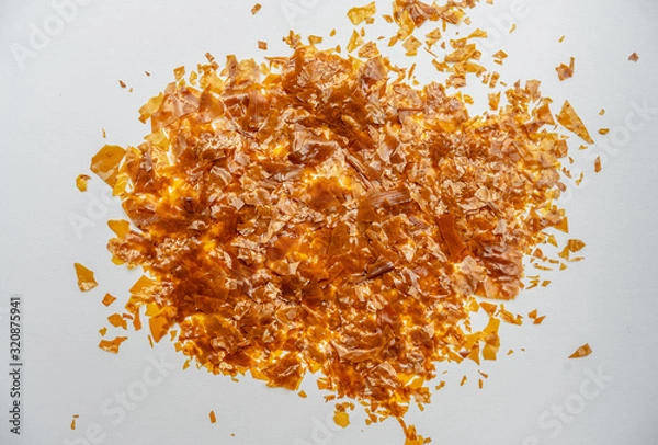 Fototapeta Shellac flakes, shellac is a  resin secreted by the female lac bug. It is dissolved in alcohol to make liquid shellac, which is used as a brush-on colorant, food glaze and wood finish.