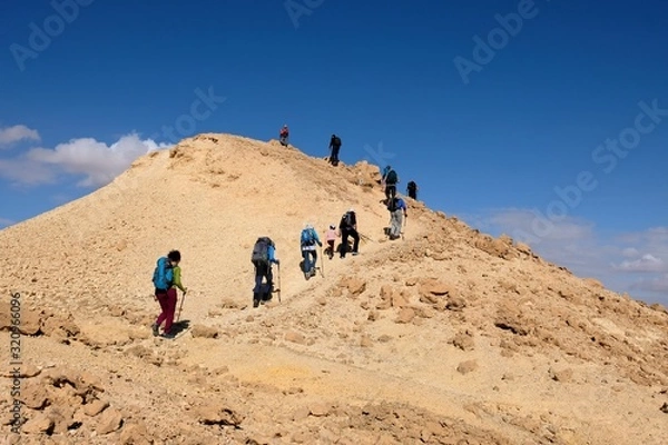 Obraz Unrecognized group of hikers on scenic trail in Negev desert mountains, Israel