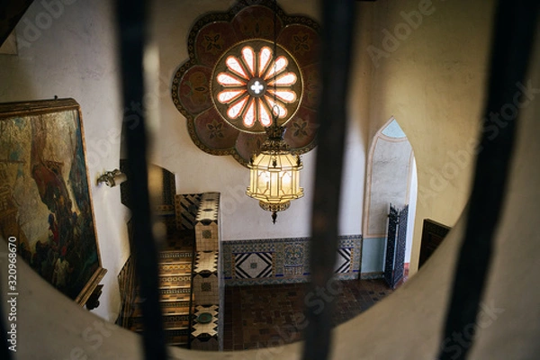 Obraz View from a barred window of the interior of a historical Spanish style building in California