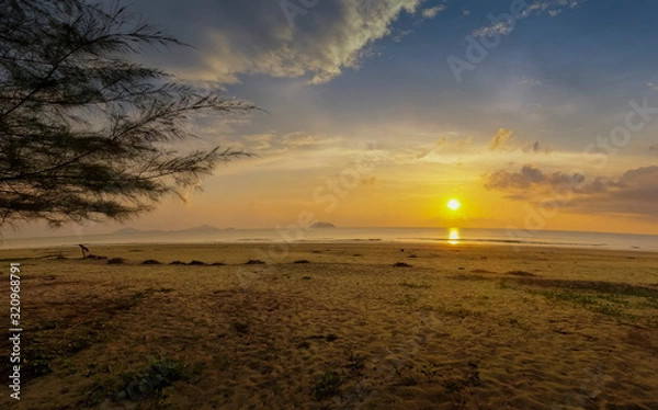 Obraz view seaside evening on sand beach with yellow sun light and cloudy sky background, sunset at Laem Son Beach, Laem Son National Park, Ranong, southern of Thailand.
