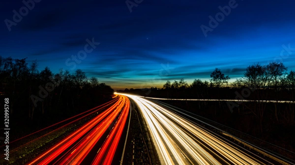 Fototapeta Zachód słońca / zmierzch niebo nad 3-pasmową autostradą o długiej ekspozycji (A46)