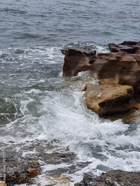Fototapeta waves crashing on rocks